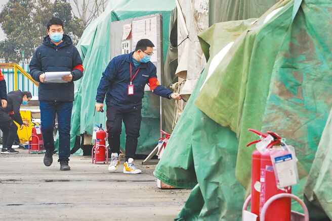 河南发生富士康郑州科技园员工集体「逃疫」步行返乡潮。图为富士康郑州科技园工作人员在检查存放的设备。（中新社）