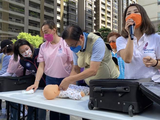 張善政挑戰穿模擬孕婦裝幫玩偶換尿布。（蔡明亘攝）