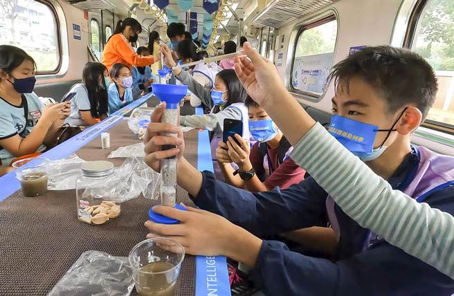 参加科普列车活动的桃园国中与桃园市自主学习3.0实验室自学生在列车上实验如何用砂石将脏水滤清。（邱俪萍老师提供）