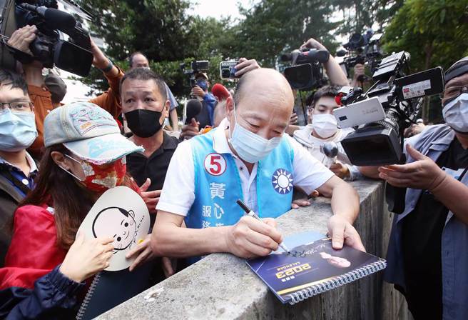 韩国瑜（中）出席黄心华竞总成立大会，1位粉丝突破重围向他索取签名。（范扬光摄）
