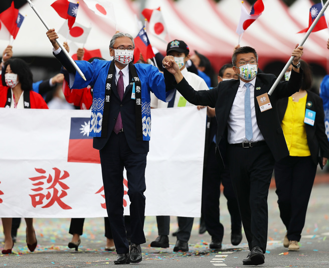 图为庆祝中华民国111年国庆大会，来自日本的19名日华恳谈会议员在会长古屋圭司（左）的率领下，与立法院副院长蔡其昌（右）一起手牵手参加游行，象徵台日友好。（资料照,季志翔摄）