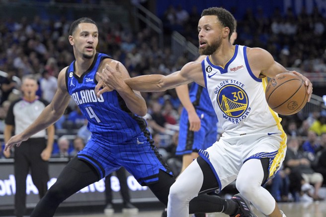 柯瑞(右)一手运球，另一手却被萨格斯夹住了。(美联社)