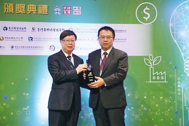 群益证在第二届《工商时报数位金融奖》获一金二优佳绩，总经理李文柱（右）自期交所董事长吴自心手中接过「绿色数位金融奖」金质奖座。图／群益证提供