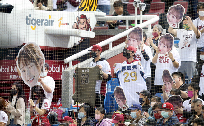 乐天桃猿球迷在本垒后方高举啦啦队女神林襄的照片，来干扰中信兄弟先发投手德保拉投球。（范扬光摄）