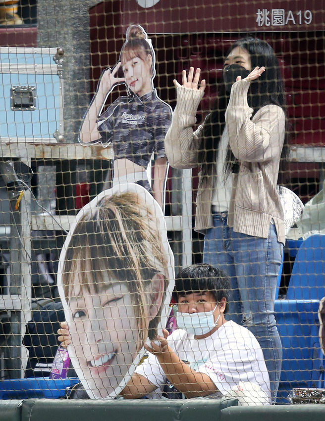 乐天桃猿球迷在本垒后方高举啦啦队女神林襄的照片，来干扰中信兄弟先发投手德保拉投球。（范扬光摄）