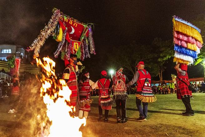 五峰乡赛夏族矮灵祭，年轻人扛肩旗带领族人绕圈跳舞「迎灵」。（罗浚滨摄）