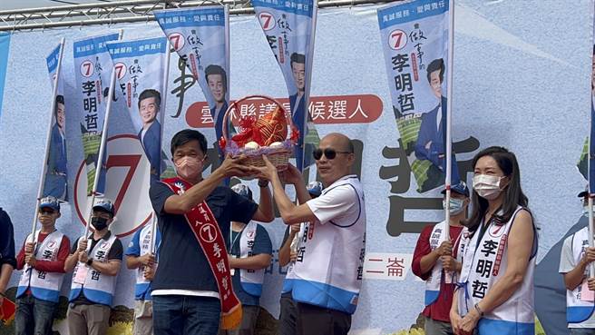 韩国瑜为小舅子李明哲送上粽子，旁为李佳芬。（李明哲竞选总部提供）
