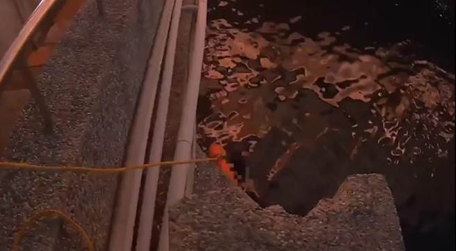 员警获报后与报案民眾一同到现场先抛救生圈给郑女。（翻摄照片／高雄洪靖宜传真）