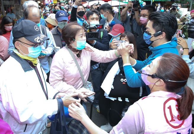 国民党台北市市长候选人蒋万安（右后），6日陪同市议员候选人李彦秀（右前）赴内湖737市场扫街拜会，现场受到摊商及大批市场内採买民眾欢迎。（陈俊吉摄）
