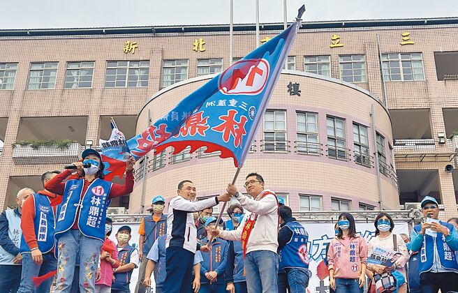 新北市长侯友宜（左持旗者）到三重替国民党议员候选人林鼎超（右持旗者）造势，授旗并预祝他旗开得胜。（吕健豪摄）