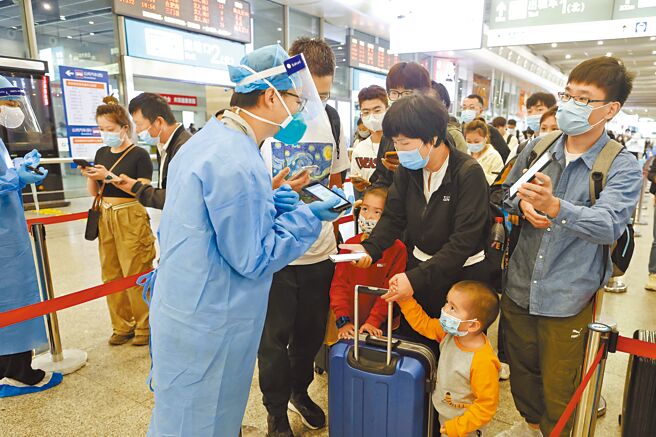 工作人員在鐵路上海虹橋站對抵達旅客進行健康碼核驗工作。（中新社）