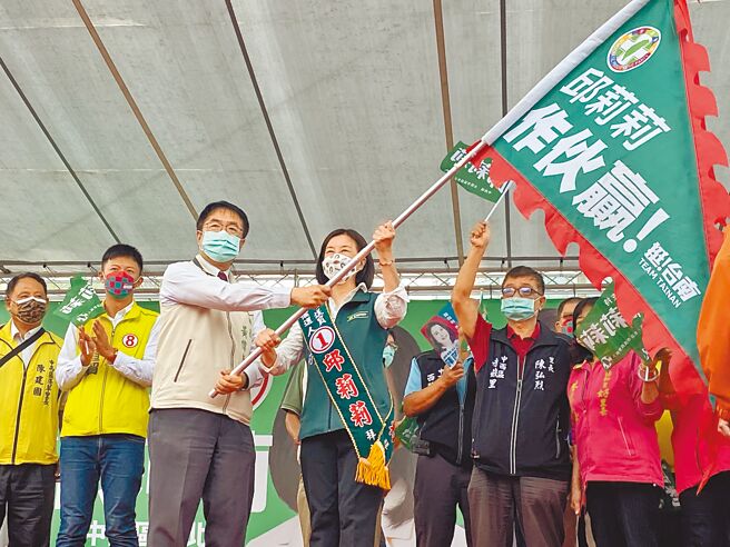 台南市长黄伟哲（左）授旗给邱莉莉（右），表示未来在议会要推动市政顺利、监督市政，最好的黄金阵容就是由邱莉莉带头。（曹婷婷摄）