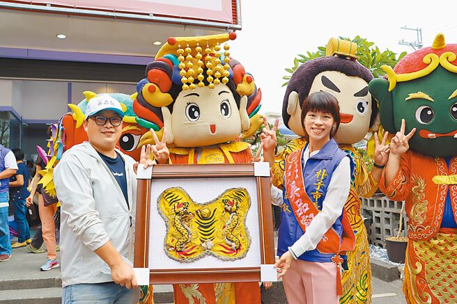 嘉义县无党籍朴子市长候选人吴品叡（右）争取连任，5日竞选总部成立，嘉义县刺绣文化学会理事长周让廷（左）特地送上炮炸过的虎爷神明衣，祝福她挺过抨击、顺利连任。（吕妍庭摄）