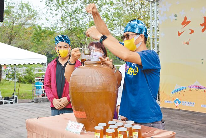 眾人将5年前酿造的柠檬酵素开封，为「六堆秋收祭」热闹揭开序幕。（林和生摄）