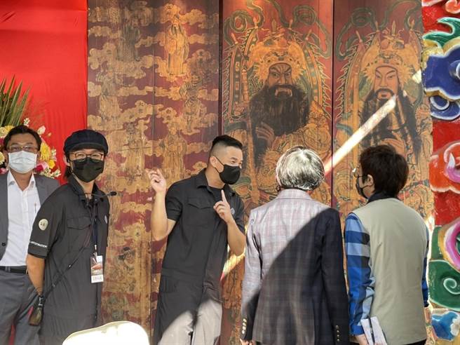 修復师蔡舜任（右三）向市府人员解说修復过程，后方图像为潘丽水原图復刻。（李俊淇摄）