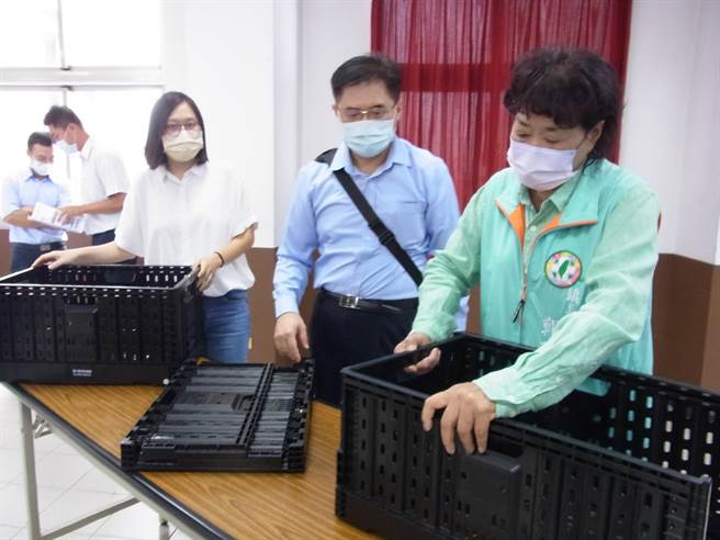 云林县西螺果菜市场董事长郑玲惠（右），示范如何使用塑胶折迭篮。（张朝欣摄）