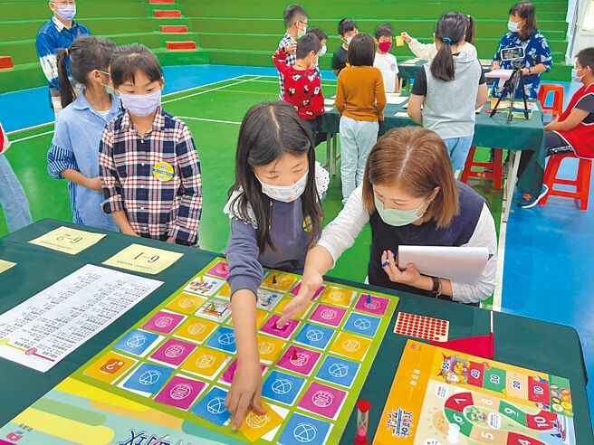 桃园市客家局举办伯公神助攻客家桌游比赛，参赛学童聚精会神只为求得竞赛好成绩。（吕筱蝉摄）