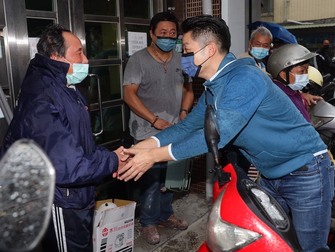 国民党台北市长候选人蒋万安（右）8日出席「喜迎尊王 保境文山」景美集应庙平安绕境大典，并且向在场的民眾握手拜票致意。（季志翔摄)