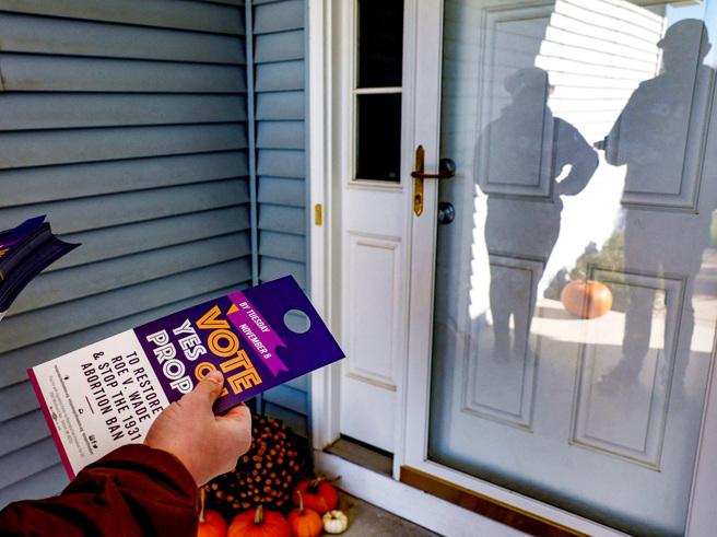 圖為密西根州支持修改州憲法、保障墮胎權的人士發送傳單。（圖／路透社）