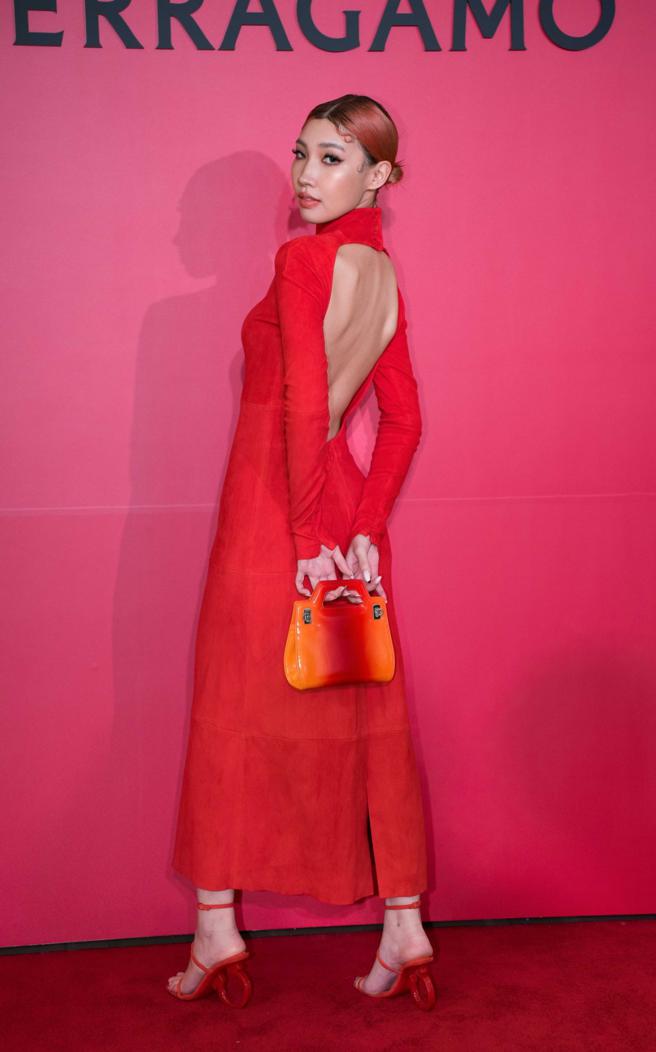 Karencici身穿橘紅色貼身洋裝，背面的挖空設計性感十足，不過此次活動最想帶走FERRAGAMO Gancino造型跟飾高跟鞋4萬5900元、搭配紅色麂皮長洋裝 19萬9000元、夕陽漸層色迷你手提包 6萬9900元。（吳松翰攝）