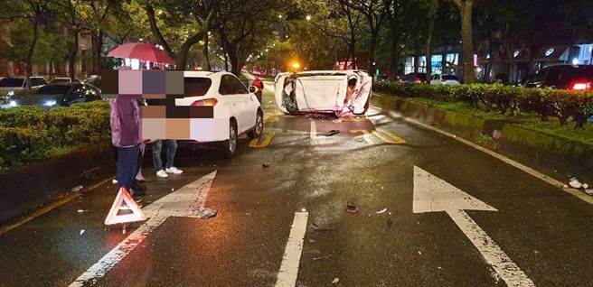 北市堤顶大道8日晚上7时许惊传翻车意外，一辆白色休旅车失控呈90度翻覆。(翻摄照片／林郁平台北传真）