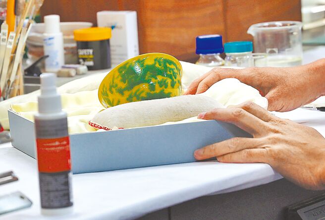 「明弘治款娇黄绿彩双龙小碗」于去年2月3日发现破损，预计下周即能修復完成。图为文物修护师7日在修护室专注地修復双龙小碗。（刘宗龙摄）