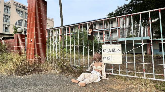 近来民眾发现华济永安高中的校门口，被挂上一颗假人头，旁边还躺着一具衣衫不整的娃娃假人。（张毓翎摄）