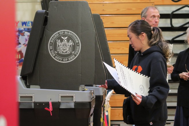 美国期中选举今天投票。图为纽约选民在曼哈顿中城公立第116小学的投票所使用投票机扫描选票。（图/ 中央社）