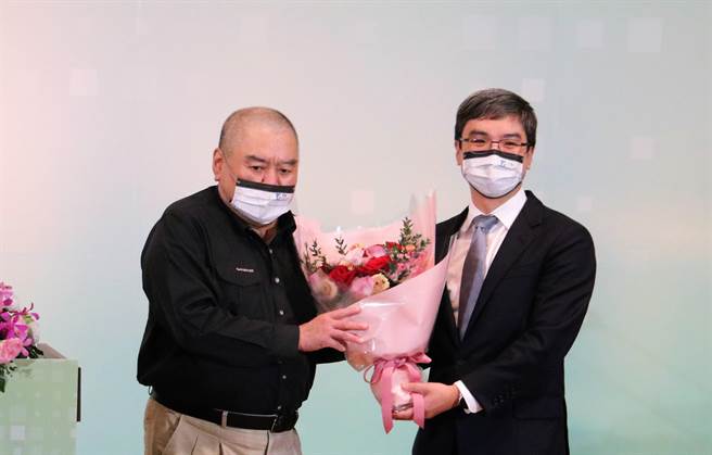 润泰集团总裁尹衍梁(左)获选为工研院院士，由任职南山人寿董事长的儿子尹崇尧献花致意。(唐奖教育基金会提供／李侑珊台北传真)