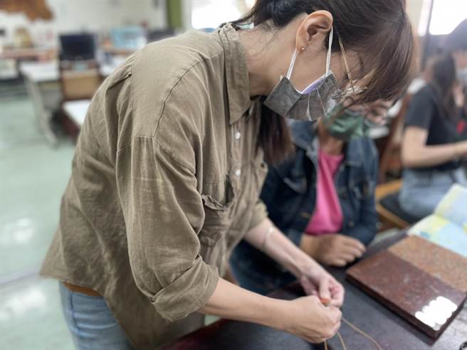 训练师黄冠纶，本身就是重器障，2014年到中心上课，越学越上手，到后来自己摆摊创业和接案，最后还被企业聘请设柜，重回皮件班已经变成老师的身分。（洪靖宜摄）