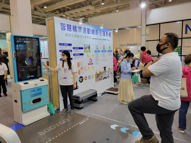 （禾青医电技术长陈纪鼎(右)和真医健康公司服务人员周筠雅(左)，11日在国际健康促进生活赋能专区，示范市价42万元的BODYGO体适能评估系统操作。图／顏瑞田）