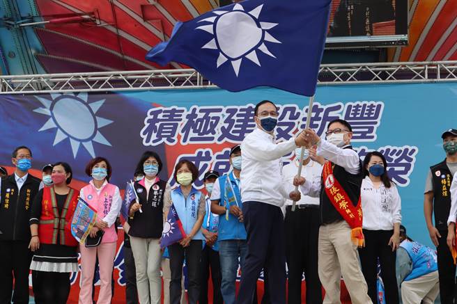 国民党主席朱立伦（前左）受党旗予张镇荣。（邱立雅摄）