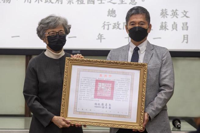 中央研究院首名戏曲院士曾永义日前辞世，文化部长李永得（右）12日代表颁赠总统褒扬令，由曾永义遗孀陈媛（左）代表受赠，表彰曾永义一生对戏曲研究及弘扬传统艺术的辛勤奉献。（图/ 中央社）