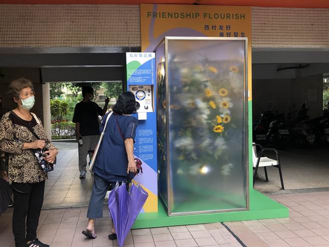创作团队「温度物所」在国宅社区通往中兴公园的通道，打造花卉展示作品〈友好发生〉，还设计了互动扭蛋机。（张芷瑜摄）