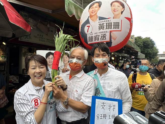 无党籍台北市长候选人黄珊珊13日「回娘家」赴东湖市场扫街拜票，东湖市场自治会长林健和还亲自送上绑着「高票当选」红布条的宜兰葱，要祝黄珊珊顺利当选。（黄婉婷摄）