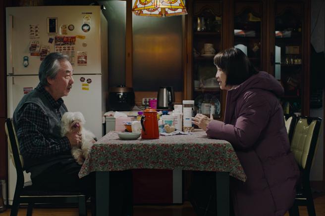 鄭東煥（左）在《花路阿珠媽》中飾演一位熱心的保全大叔，幫助在異國迷路的洪慧芳。（采昌提供）