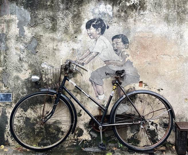 马来西亚槟城州的首府「乔治市」2008被联合国教科文组织列为世界文化遗产后，吸引许多旅客到访，立陶宛画家尔纳斯壁画更成为拍照打卡热点，图为画作《姐弟共骑》。（吴娮翎摄）