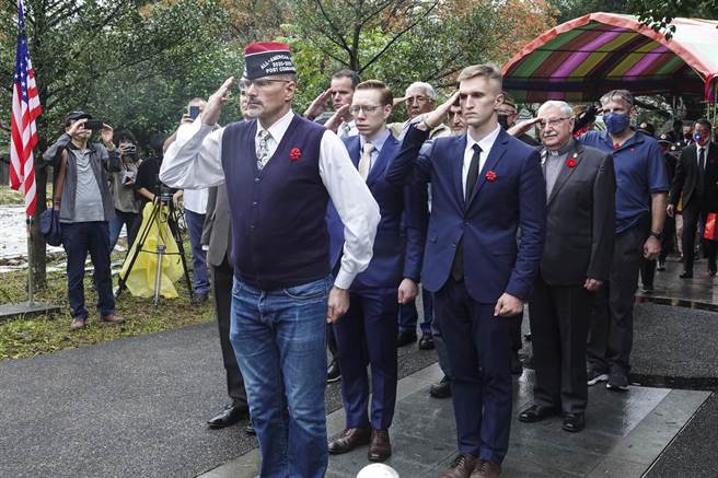 參加二戰受難戰俘追思會的與會人員向紀念碑獻花並敬禮。（黃子明攝）