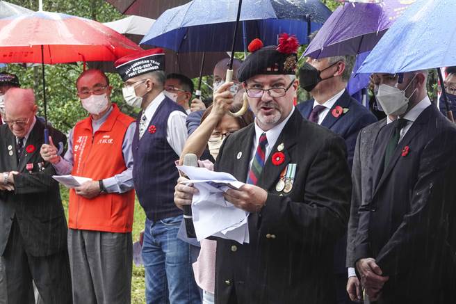 在金瓜石「國際終戰和平紀念園區」追思戰俘活動中，與會人士在雨中朗讀頌詞。（黃子明攝）