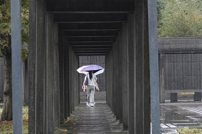 民眾走過金瓜石「國際終戰和平紀念園區」長廊，前往參觀刻滿戰俘名單與國籍資料的紀念牆。（黃子明攝）