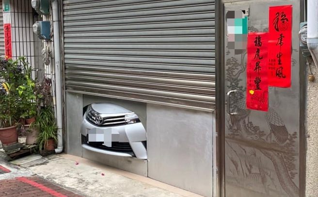 台南一戶住家的一樓車庫被目擊停入轎車後，疑似因車庫不夠大，鐵捲門關一半後，轎車露出「小車頭」，其餘空間用鐵板隔著。（翻攝自臉書「路上觀察學院」）