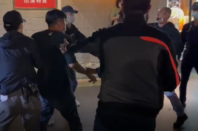 民眾怒骂陈时中「採购黑箱、咸猪手」，遭维安人员带离现场。（图／中天新闻）