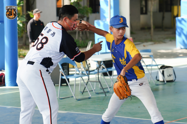 统一狮投手胡智为（左）指导金城国中棒球队球员。（统一狮提供）