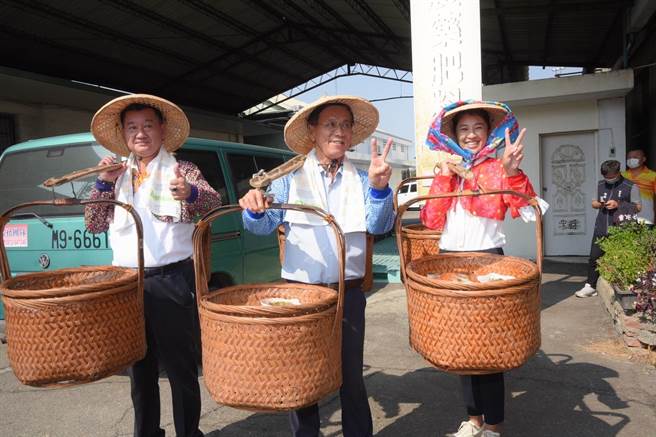 草屯农会举行千人割稻饭产业文化活动，许淑华（右起）、林明溱、简景贤担着「割稻饭」进场，场面热闹。（南投县府提供／杨静茹南投传真）