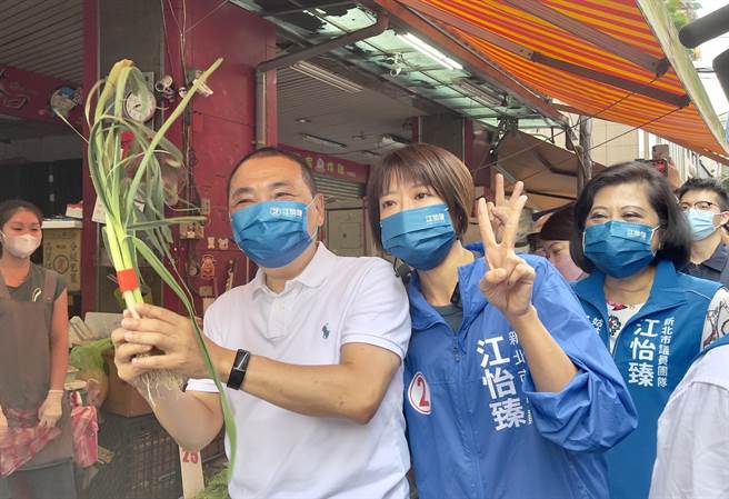 新北市长侯友宜与党内议员候选人江怡臻一起在土城延吉市场扫街，摊商送上大蒜象徵「冻蒜」。（吕健豪摄）