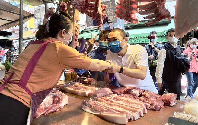 走到最熟悉的猪肉摊，侯友宜与老板娘握手致意。（吕健豪摄）