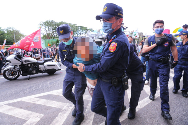 1位民眾20日趁隙跑上陈时中的竞选宣传车上，拿着刀子威胁，要求警方给他麦克风让他讲话，随后被员警压制。（图／黄世麒摄）