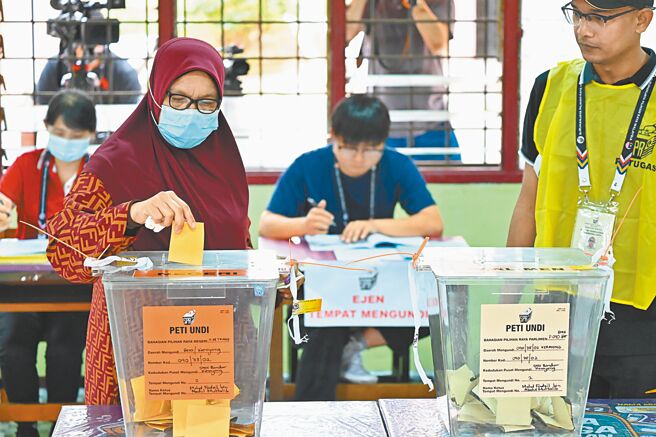 马来西亚19日举行国会下议院大选，选前民调显示，反对党领袖安华领导的「希盟」可望拿下最多席次，但预料3大政党联盟都无法取得112席以上的席次单独执政，可能导致出现「悬峙国会」的局面。据信这次大选是安华最后一次问鼎马国首相宝座的机会。图为民眾在马来西亚一处投票站投票。（新华社）