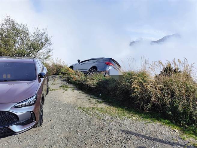 來自高雄劉姓女子昨與丈夫駕車赴合歡山，未料倒車力道過大，車子衝出懸崖，被邊坡草堆樹木卡住，以致半個車身呈現傾斜狀態，吊掛在懸崖旁，畫面相當驚險。（新城警分局提供／羅亦晽花蓮傳真）