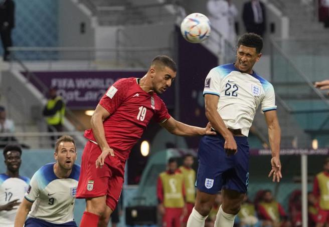 英格兰小将贝林罕（右）上半场率先顶开伊朗大门。（美联社）